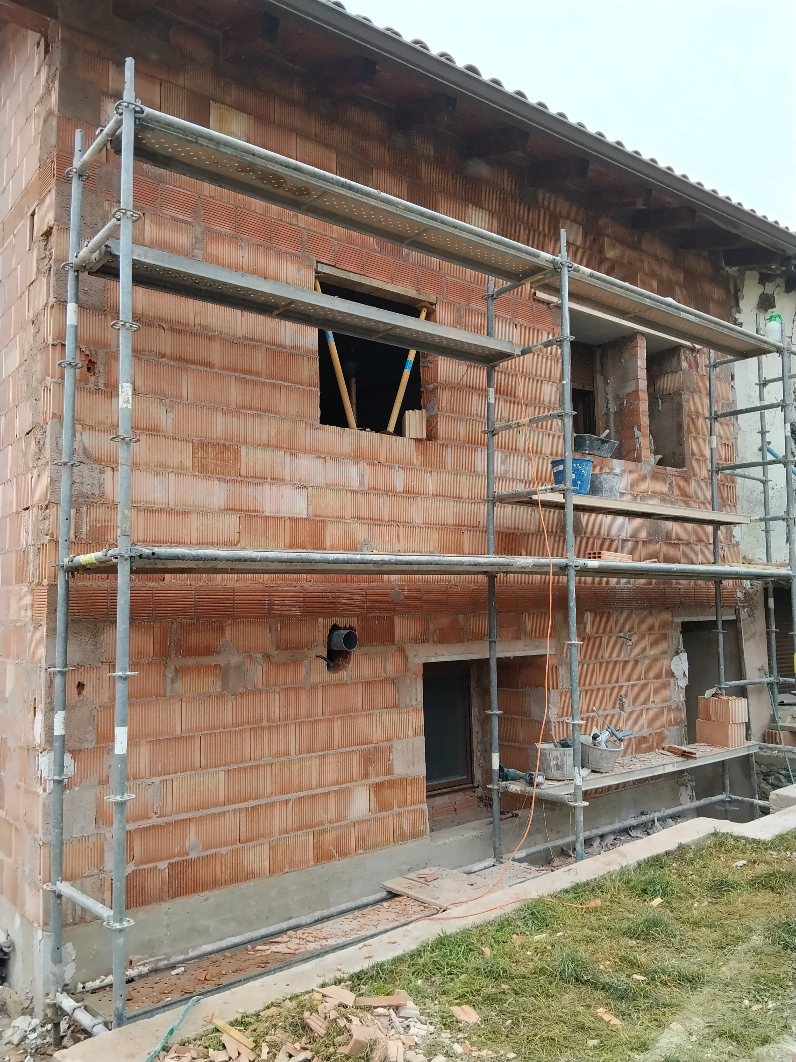Fachada de ladrillo en obra con andamio